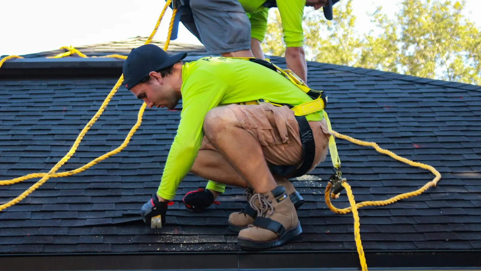 Roofing workers positioned on a large commercial roof
