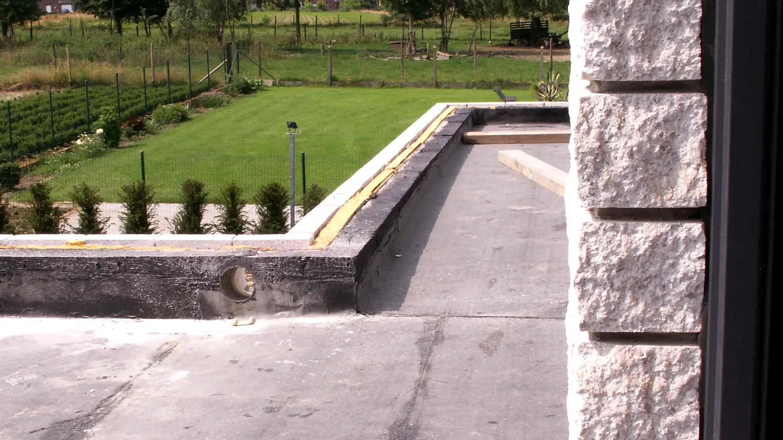 Flat roof covering being installed around a roof opening