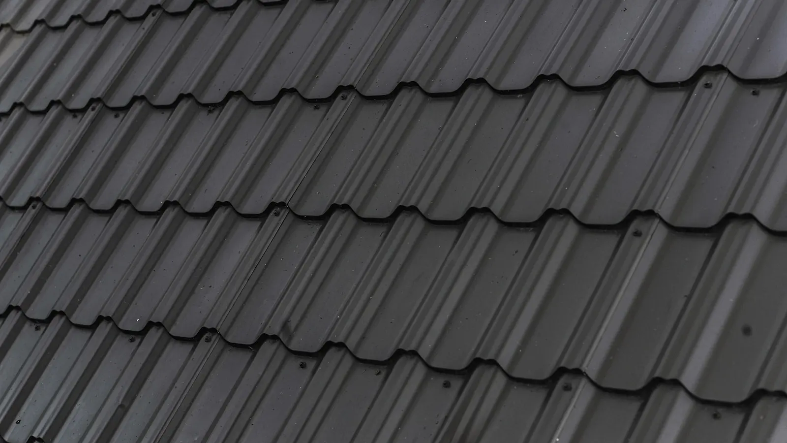 Close view of overlapping pitched-roof tiles and junctions
