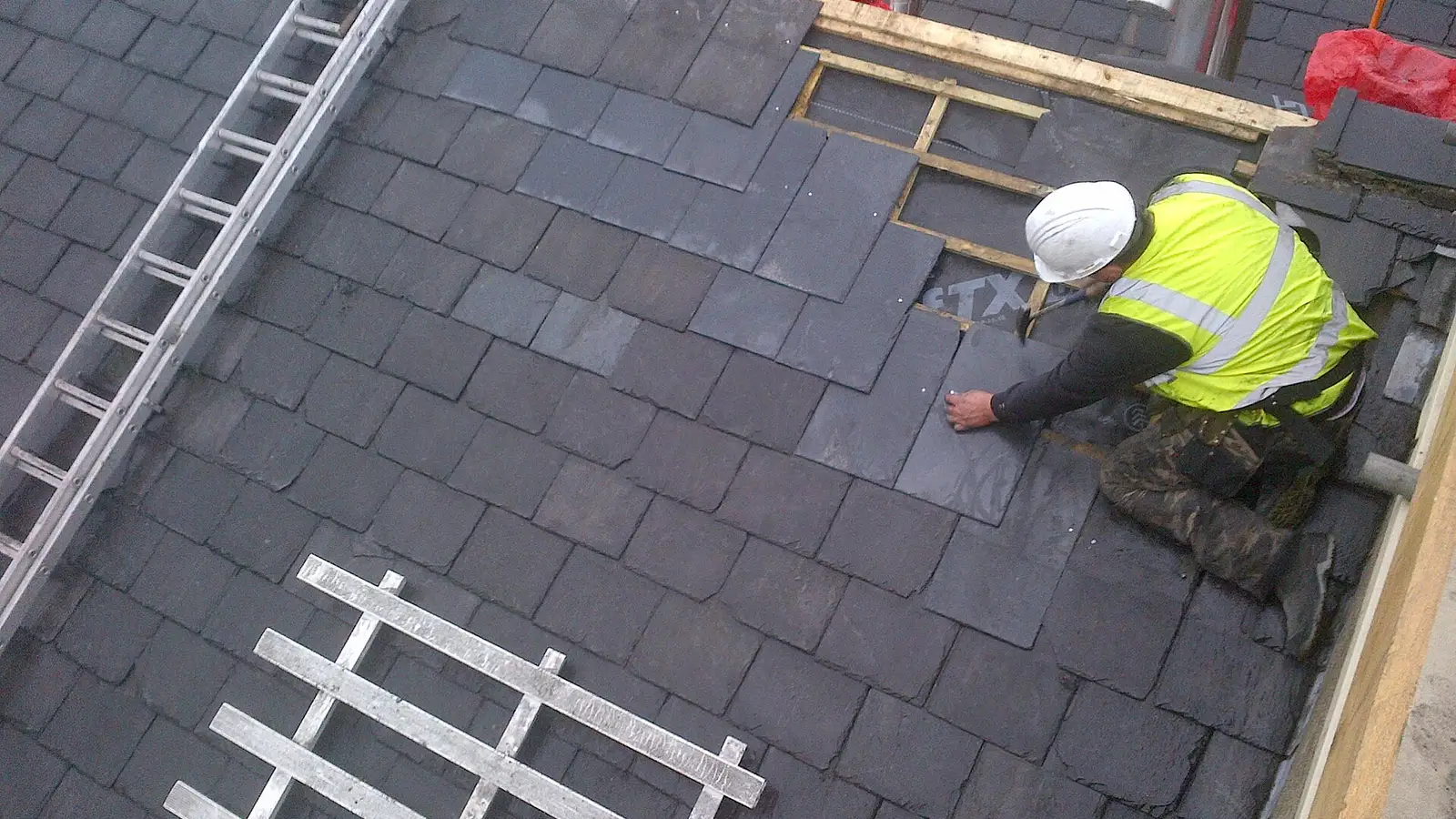Roof slates being fitted in overlapping courses